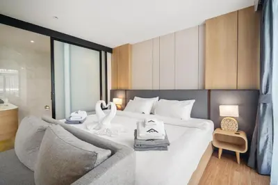 a bedroom with a white bed and a couch at Wyndham Gardens 1321 Studio 1min to Naithon Beach in Phuket Town