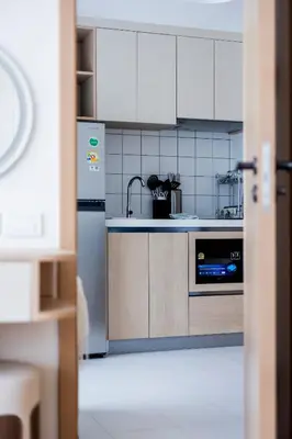 a kitchen with white cabinets and a refrigerator at FantaSea condo Kamala 205 in Kamala Beach