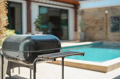 a grill sitting in front of a swimming pool at 3 Bedrooms villa walking distance to Rawai beach in Rawai Beach