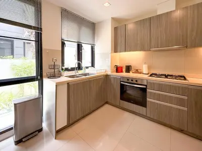 a large kitchen with wooden cabinets and a sink at Laguna Park Phuket 5BR Villa with Rooftop Pool #84194 in Laguna Phuket
