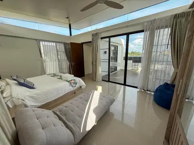 a bedroom with a bed and a sliding glass door at Laguna Park Phuket 5BR Villa with Rooftop Pool #84194 in Laguna Phuket