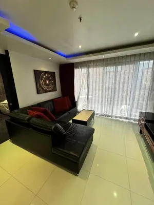 a living room with a black leather couch and a table at L08 Penthouse Suite Modern Condo On Bangla Road in Patong Beach