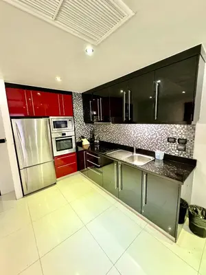 a kitchen with stainless steel appliances and red cabinets at L08 Penthouse Suite Modern Condo On Bangla Road in Patong Beach