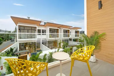 a balcony of a building with two chairs and a table at Goldena Residence Private Pool Villas in Kamala Beach