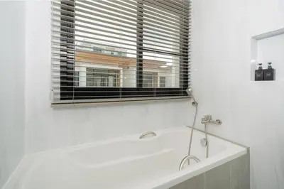 a white bath tub in a bathroom with a window at Goldena Residence Private Pool Villas in Kamala Beach