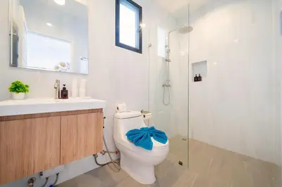 a bathroom with a toilet and a sink and a shower at Goldena Residence Private Pool Villas in Kamala Beach