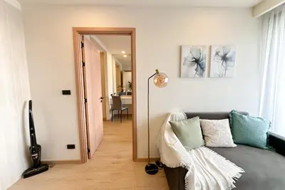 a living room with a couch and a hallway at Ozone Sky View Residence in Laguna Phuket