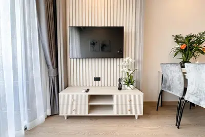 a living room with a tv on a wall at Ozone Sky View Residence in Laguna Phuket