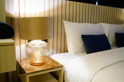 a lamp on a night stand next to a bed at Ozone Sky View Residence in Laguna Phuket