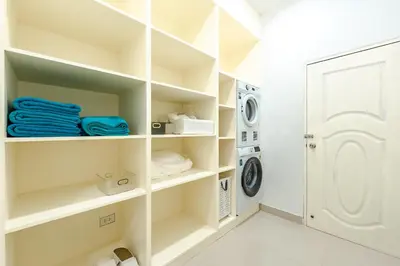 a laundry room with white shelves and a washing machine at Platinum Villa Rawai in Rawai Beach