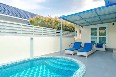 a patio with a swimming pool and blue chairs at Platinum Villa Rawai in Rawai Beach