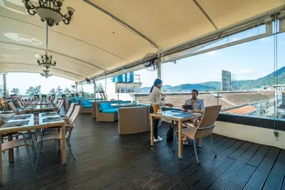 two people sitting at a table on a balcony at L01 Bangla Suites Modern Studio On Bangla Road in Patong Beach
