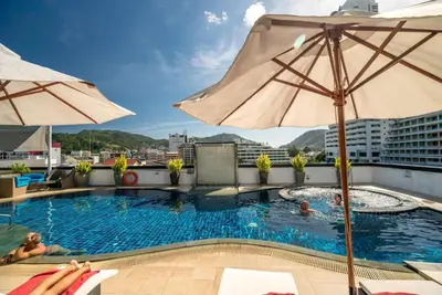 a pool on the roof of a building with an umbrella at L01 Bangla Suites Modern Studio On Bangla Road in Patong Beach