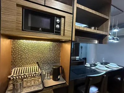 a small kitchen with a table and a microwave at The Regent Bang Tao Beach in Phuket