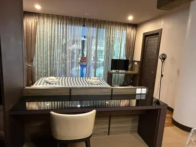 a desk with a bed and a chair in a room at The Regent Bang Tao Beach in Phuket