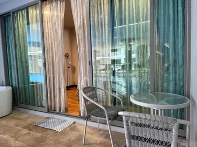 a glass table and chair in a room with a window at The Regent Bang Tao Beach in Phuket