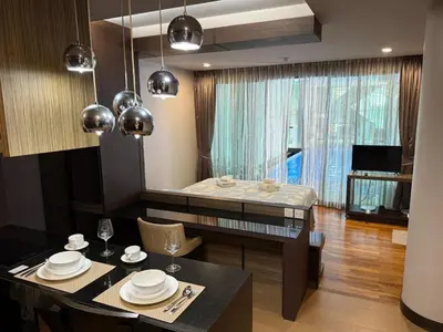 a living room with a dining table and a bed at The Regent Bang Tao Beach in Phuket