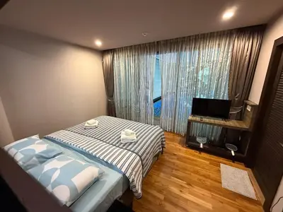 a bedroom with a bed and a large window at The Regent Bang Tao Beach in Phuket