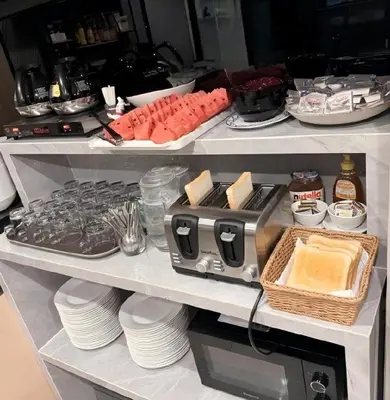 a refrigerator filled with plates and a food processor at Phuket Five Fortune Holiday Hotel in Rawai Beach