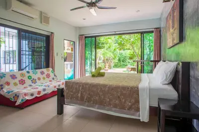 a bedroom with a bed and a couch and a window at 150 m from a paradise beach 3 bedrooms pool in Klong Muang Beach
