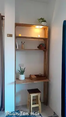 a wooden shelf with a stool in a room at Baan ton mai 2 bedrooms 400 m from the beach in Klong Muang Beach