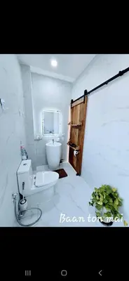 a white bathroom with a toilet and a sink at Baan ton mai 2 bedrooms 400 m from the beach in Klong Muang Beach