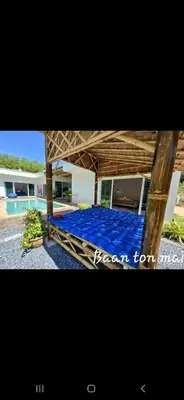 a bed with blue sheets in a house at Baan ton mai 2 bedrooms 400 m from the beach in Klong Muang Beach
