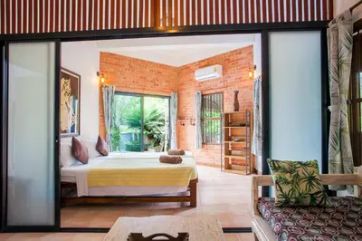 a bedroom with a bed and a large window at Villa with private pool and mountain views in Ban Khlong Son