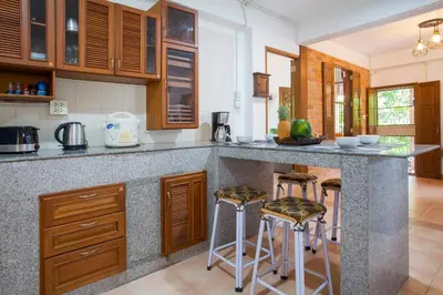 a kitchen with a granite counter top and stools at Villa with private pool and mountain views in Ban Khlong Son