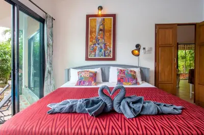 a bed with two towels in the shape of a heart at Villa with private pool and mountain views in Ban Khlong Son
