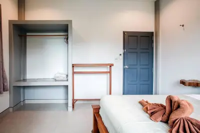 a bedroom with a bed and a blue door at Jaccuzi House 5 pl 200 m from a beautiful beach in Klong Muang Beach