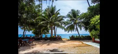 a beach with chairs and palm trees and the ocean at Jaccuzi House 5 pl 200 m from a beautiful beach in Klong Muang Beach