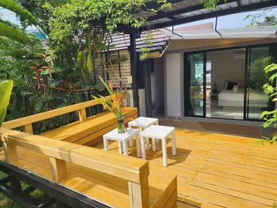 a wooden deck with two chairs and a bench at Pool Villa Suchada 2 bedrooms in Ban Khlong Haeng