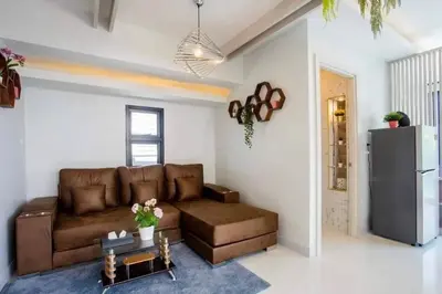 a living room with a brown couch and a refrigerator at Pool Villa Suchada 2 bedrooms in Ban Khlong Haeng