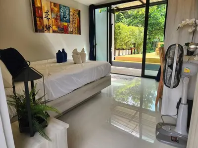 a bedroom with a bed with a fan and a window at Pool Villa Suchada 2 bedrooms in Ban Khlong Haeng