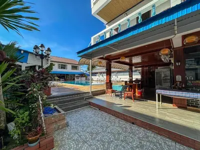 a patio of a building with a table and chairs at Rabbit Mansion Patong Hotel in Patong Beach