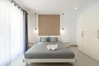 a bedroom with a bed with two shoes on it at Platinum Villa 4 bedrooms Rawai in Rawai Beach