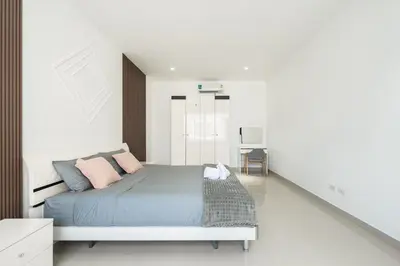 a bedroom with a bed with pink and blue pillows at Platinum Villa 4 bedrooms Rawai in Rawai Beach
