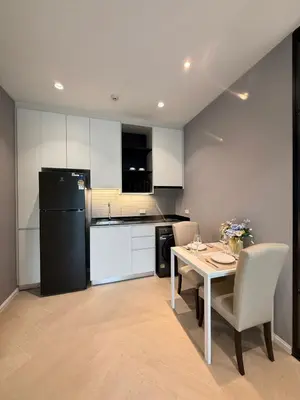 a kitchen with a table and a black refrigerator at Andaman 3 in Ban Thalat Choeng Thale