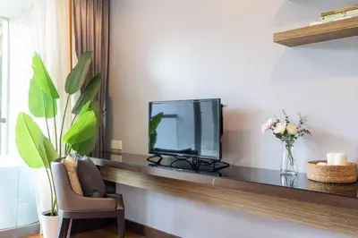 a living room with a television and a chair at Majestic 2BR Residence with garden view in Regent in Bang Tao Beach