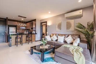 a living room with a couch and a table at Majestic 2BR Residence with garden view in Regent in Bang Tao Beach