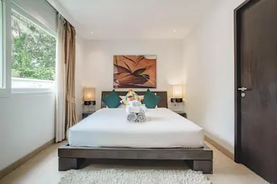 a bedroom with a white bed and a window at Raya Villa 2 Bed Beachfront Villa Private Pool in Rawai Beach