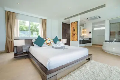 a bedroom with a large bed and a bath tub at Raya Villa 2 Bed Beachfront Villa Private Pool in Rawai Beach