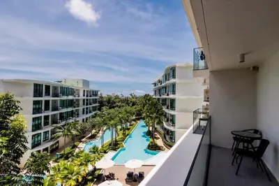 an apartment balcony with a view of a pool at La Vita Phuket by Beringela in Rawai Beach