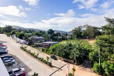 a city street with cars parked in a parking lot at La Vita Phuket by Beringela in Rawai Beach