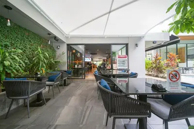 a restaurant with tables and chairs and plants at Diamond Bangtao Beach 1 bedroom in Bang Tao Beach