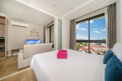 a bedroom with a white bed with a pink towel on it at Diamond Bangtao Beach 1 bedroom in Bang Tao Beach