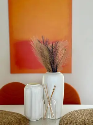 two white vases with feathers in them on a table at Jungle House Phuket - Seaview Retreat in Patong Beach