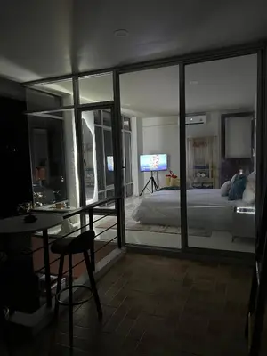 a bedroom with a bed and a table and a tv at Jungle House Phuket - Seaview Retreat in Patong Beach