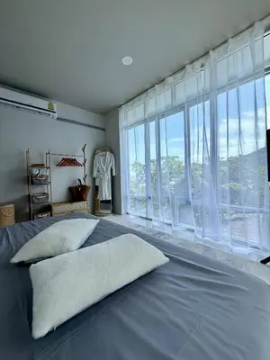 a bedroom with a large bed with large windows at Jungle House Phuket - Seaview Retreat in Patong Beach